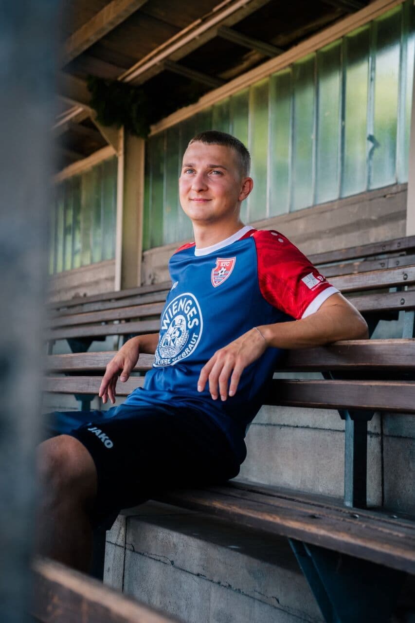 Junger Krefelder im blau-roten Heimtrikot auf der Holztribüne der Grotenburg